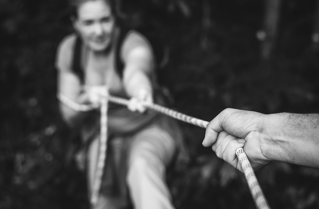 Woman climbing up a rope